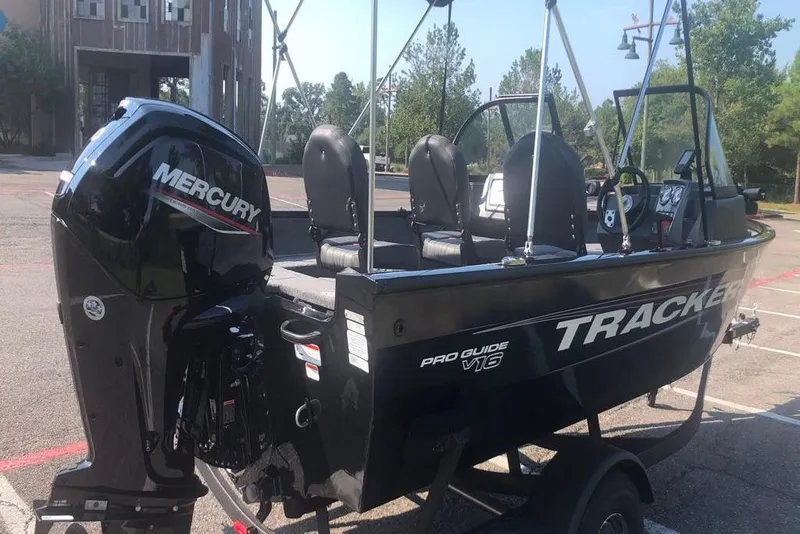 Slide: The Image of 2026 Tracker Pro Guide V-16 WT boat with Mercury engine in parking lot. - 4
