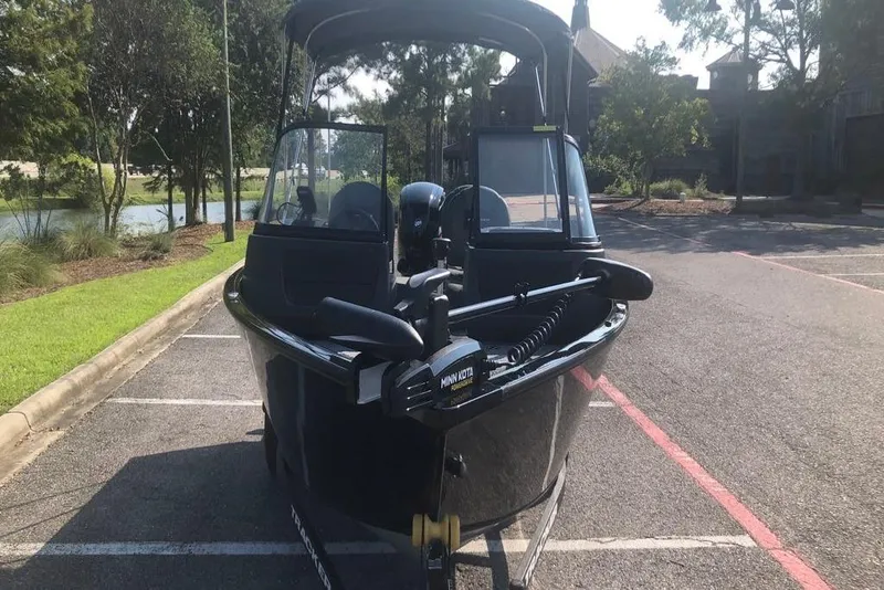 Slide: The Image of 2026 Tracker Pro Guide V-16 WT boat parked near a scenic lake. - 7