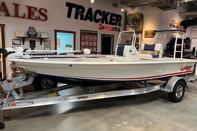 The Image of 2025 Mako 18 Pro Skiff Patriot Edition boat displayed in showroom on trailer. - 0