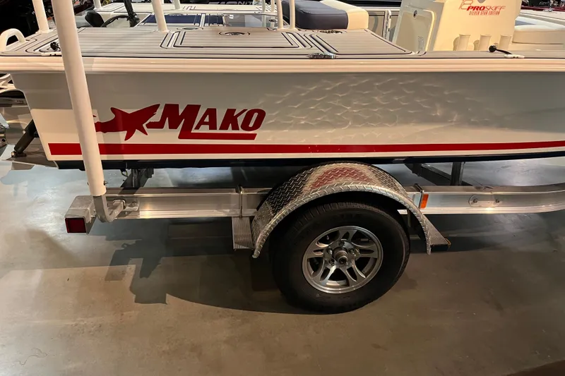 Slide: The Image of 2025 Mako 18 Pro Skiff Patriot Edition boat on trailer, showroom display. - 2