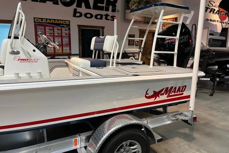 Slide: The Image of 2025 Mako 18 Pro Skiff Patriot Edition boat displayed in showroom on trailer. - 3