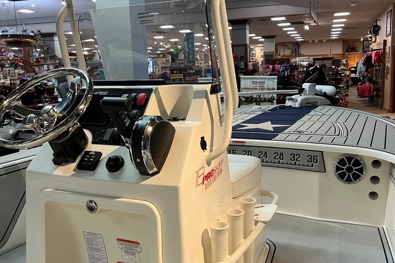 Slide: The Image of 2025 Mako 18 Pro Skiff Patriot Edition boat interior with steering wheel and control panel. - 4