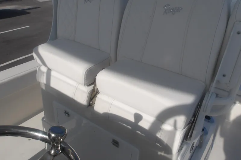 Slide: The Image of 2025 Ranger 2360 Bay boat with white cushioned seats and steering wheel. - 26