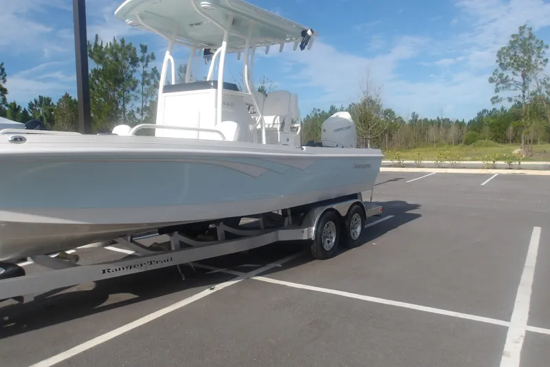 Slide: The Image of 2025 Ranger 2360 Bay boat on trailer in parking lot, clear sky background. - 6