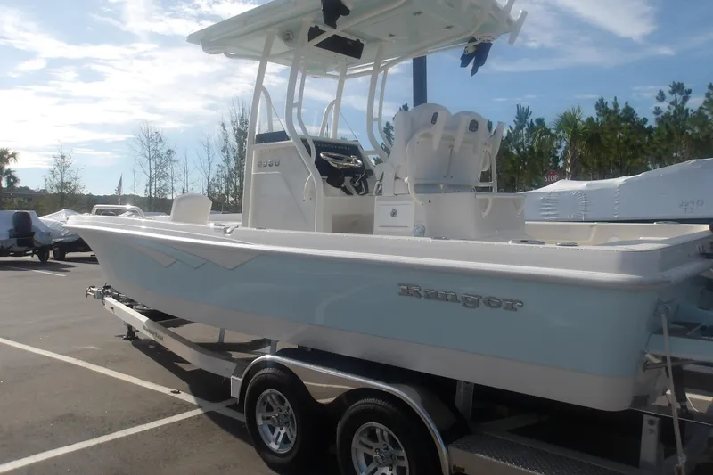 Slide: The Image of 2025 Ranger 2360 Bay boat on trailer in sunny outdoor setting. - 7