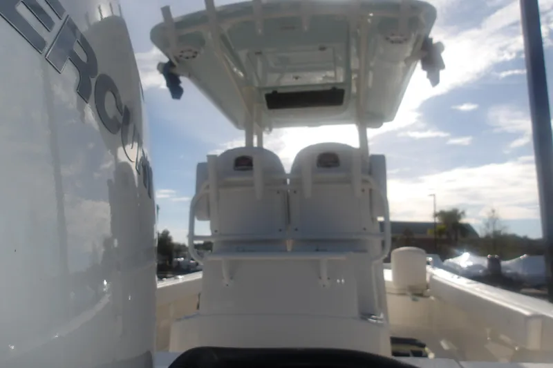 Slide: The Image of 2025 Ranger 2360 Bay boat interior with Mercury engine, showcasing seating and console under a clear sky. - 2