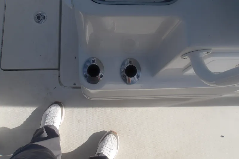 Slide: The Image of Deck of 2025 Ranger 2360 Bay boat with rod holders and footwear visible. - 12