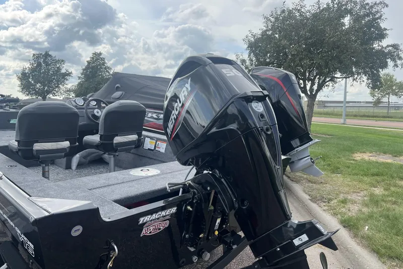 Slide: The Image of 2026 Tracker Super Guide V-16 SC boat with Mercury outboard motor, parked outdoors. - 2