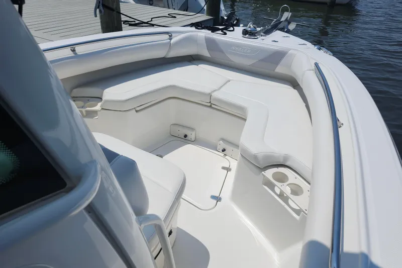 Slide: The Image of 2016 Boston Whaler 250 Outrage boat interior with white seating and cup holders. - 12