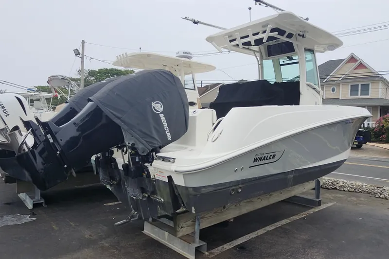 Slide: The Image of 2016 Boston Whaler 250 Outrage boat with Mercury outboard engines, parked on a trailer. - 2