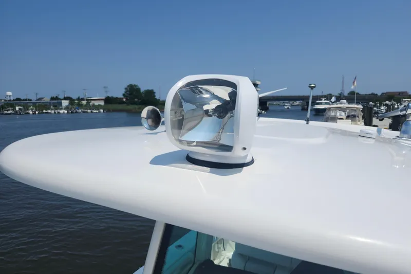 Slide: The Image of 2016 Boston Whaler 250 Outrage spotlight on boat roof, docked near marina. - 23