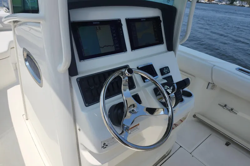Slide: The Image of 2016 Boston Whaler 250 Outrage helm with dual Simrad displays and stainless steel steering wheel. - 3