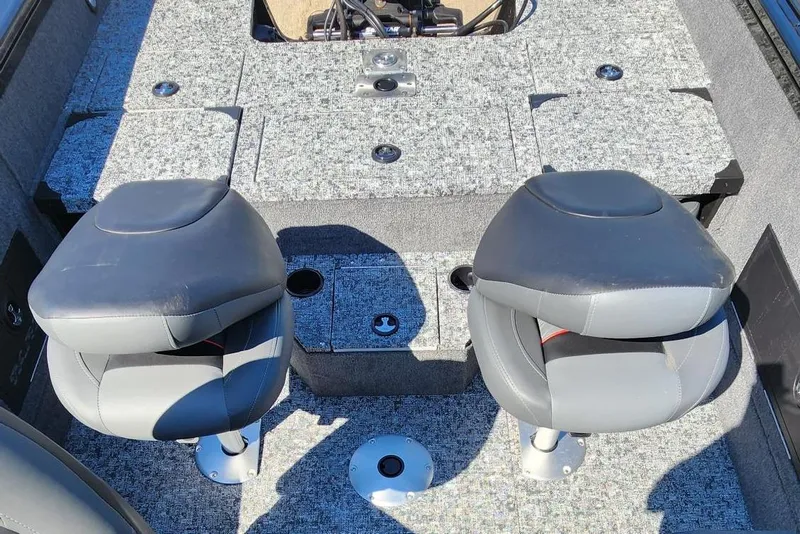Slide: The Image of 2026 Tracker Targa V-18 Combo boat interior with two gray seats and carpeted flooring. - 10