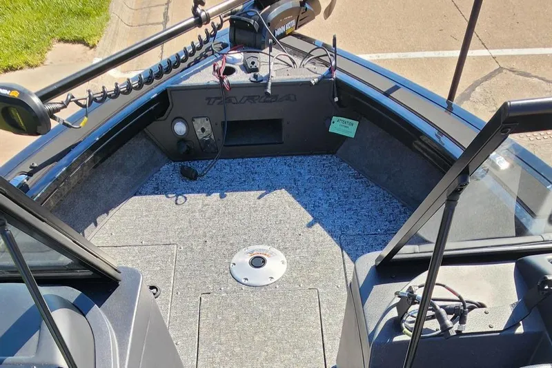 Slide: The Image of 2026 Tracker Targa V-18 Combo boat interior with fishing equipment and carpeted deck. - 13