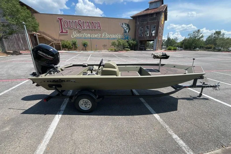 Slide: The Image of 2026 Tracker Grizzly 1754 SC boat on trailer in parking lot, Louisiana Sportsman's Paradise backdrop. - 4