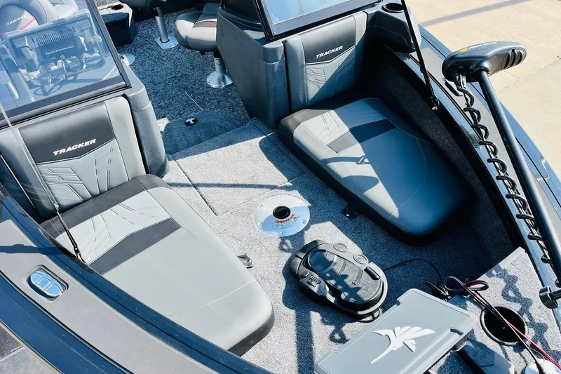 Slide: The Image of 2026 Tracker Targa V-18 Combo boat interior with gray seating and fishing equipment. - 17