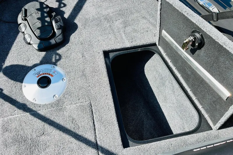 Slide: The Image of 2026 Tracker Targa V-18 Combo boat interior with storage compartment and control panel. - 20