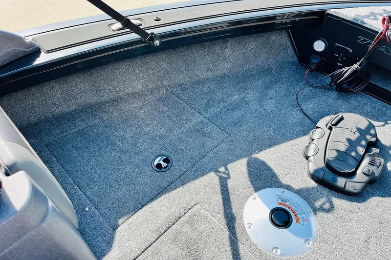 Slide: The Image of 2026 Tracker Targa V-18 Combo boat interior with carpeted flooring and control panel. - 21