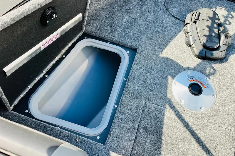 Slide: The Image of 2026 Tracker Targa V-18 Combo boat interior with storage compartment and control panel. - 22