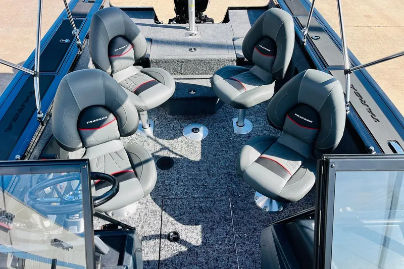 Slide: The Image of 2026 Tracker Targa V-18 Combo boat interior with four gray seats and carpeted flooring. - 26