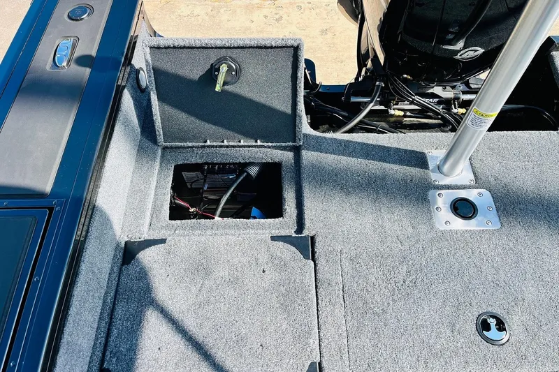 Slide: The Image of 2026 Tracker Targa V-18 Combo boat interior with open storage compartment and motor view. - 67