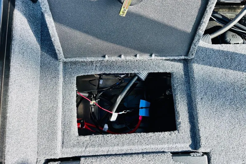 Slide: The Image of 2026 Tracker Targa V-18 Combo boat interior wiring compartment with carpeted finish. - 68