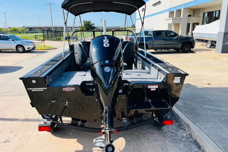 Slide: The Image of 2026 Tracker Targa V-18 Combo boat with 150 HP engine, parked outdoors. - 7