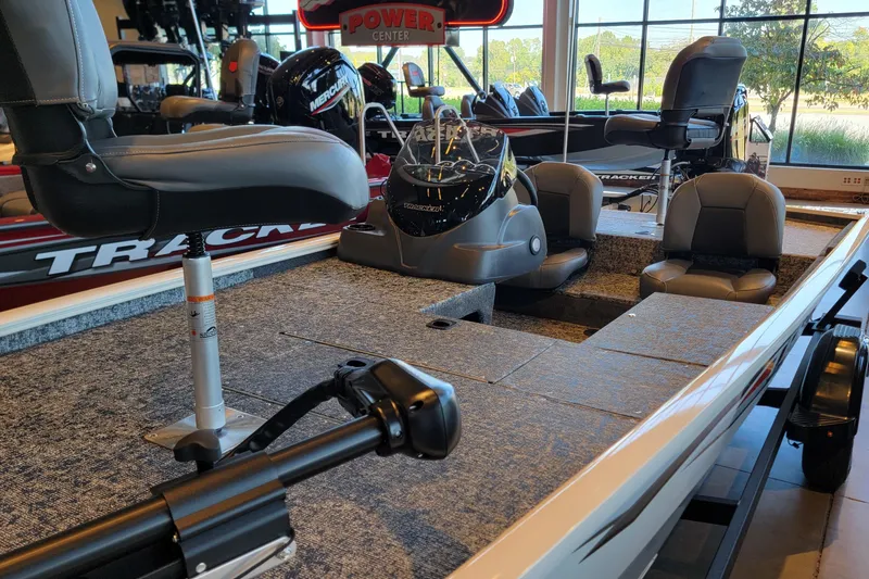 Slide: The Image of 2026 Tracker Pro 170 boat interior with seating and control console in showroom. - 3