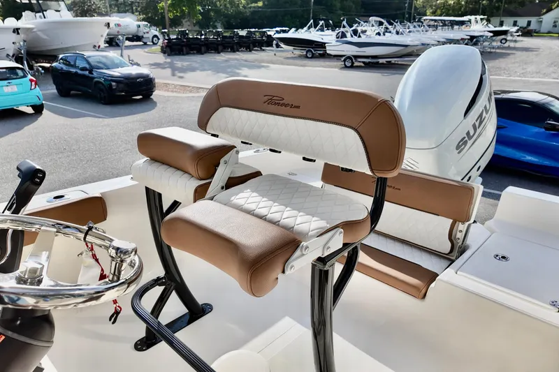 Slide: The Image of 2026 Pioneer 220 Baysport boat interior with brown and white seating, Suzuki engine visible. - 10