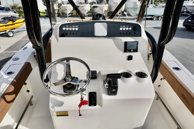 Slide: The Image of 2026 Pioneer 220 Baysport boat dashboard with steering wheel and controls. - 11