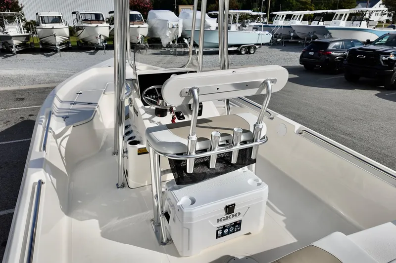Slide: The Image of 2026 Pioneer 220 Baysport boat interior with console and seating, parked in a marina. - 12