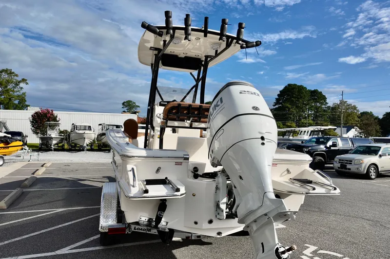 Slide: The Image of 2026 Pioneer 220 Baysport boat with Suzuki 250 engine, parked outdoors. - 3