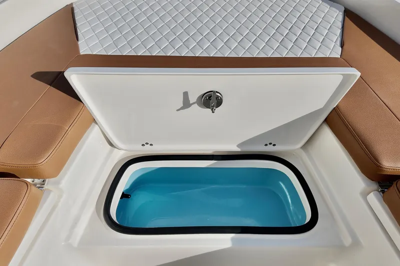 Slide: The Image of 2026 Pioneer 220 Baysport boat with open storage compartment and cushioned seating. - 6