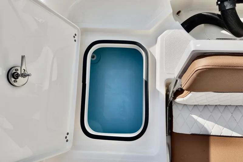 Slide: The Image of Livewell compartment on 2026 Pioneer 220 Baysport boat, featuring a blue interior and adjacent seating. - 8