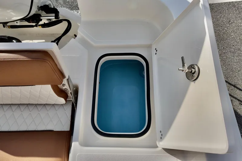 Slide: The Image of 2026 Pioneer 220 Baysport boat livewell with open lid and cushioned seating. - 9