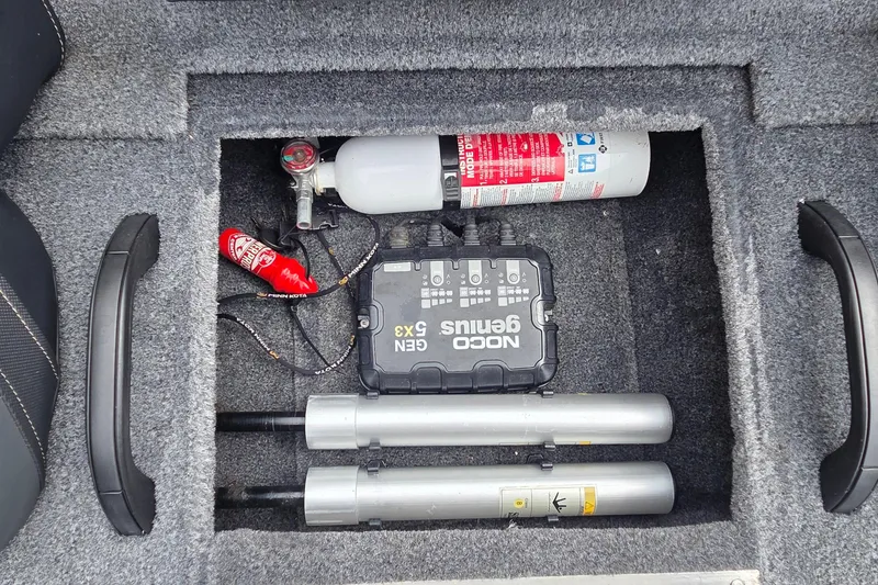 Slide: The Image of Storage compartment of 2023 Tracker Pro Team 195 TXW with fire extinguisher and NOCO Genius charger. - 20