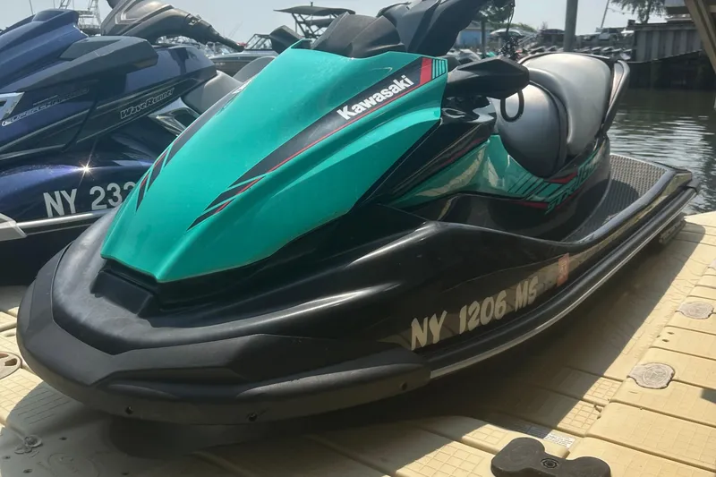 Slide: The Image of 2021 Kawasaki Jetski STX 160X seat and controls, featuring safety labels and textured footrests. - 3