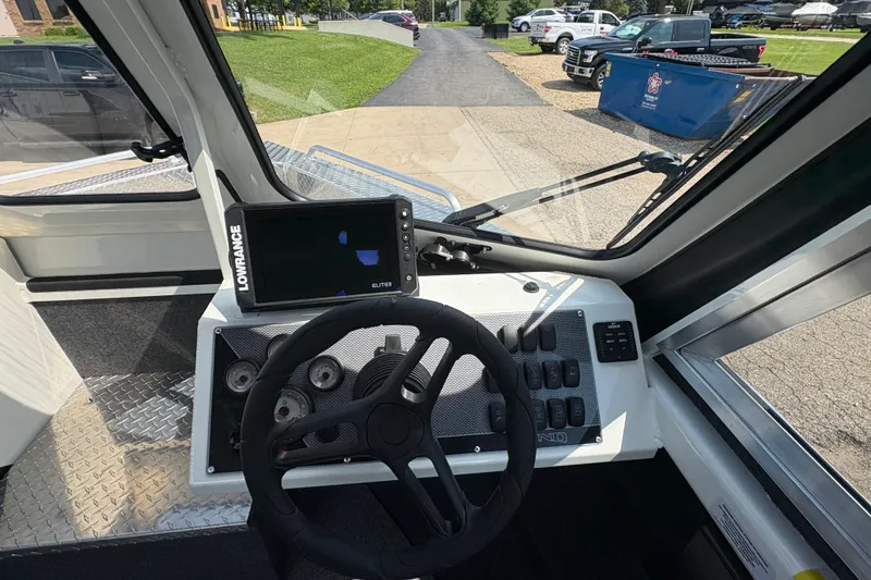 Slide: The Image of Interior view of 2026 Lund 210 HG boat dashboard with steering wheel and navigation system. - 18