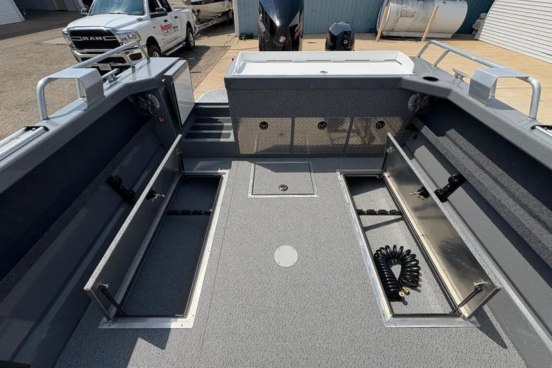 Slide: The Image of 2026 Lund 210 HG boat interior with open storage compartments and coiled hose. - 32