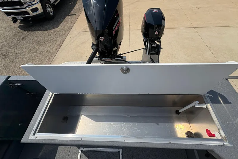 Slide: The Image of 2026 Lund 210 HG boat with open storage compartment and dual outboard motors. - 39