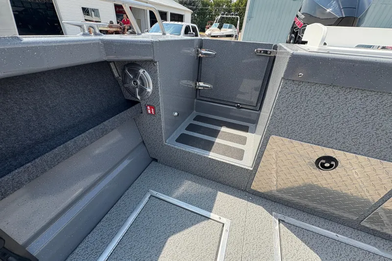 Slide: The Image of Interior of 2026 Lund 210 HG boat with gray textured flooring and storage compartments. - 40