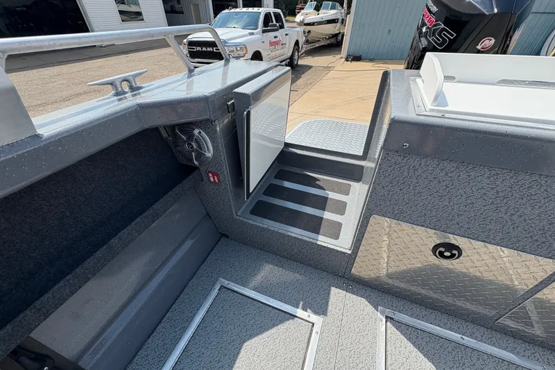 Slide: The Image of 2026 Lund 210 HG boat interior with open storage compartment and visible deck details. - 41