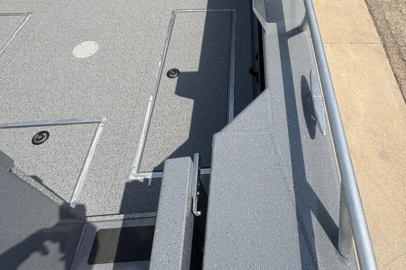 Slide: The Image of 2026 Lund 210 HG boat deck with storage compartments and textured surface. - 44