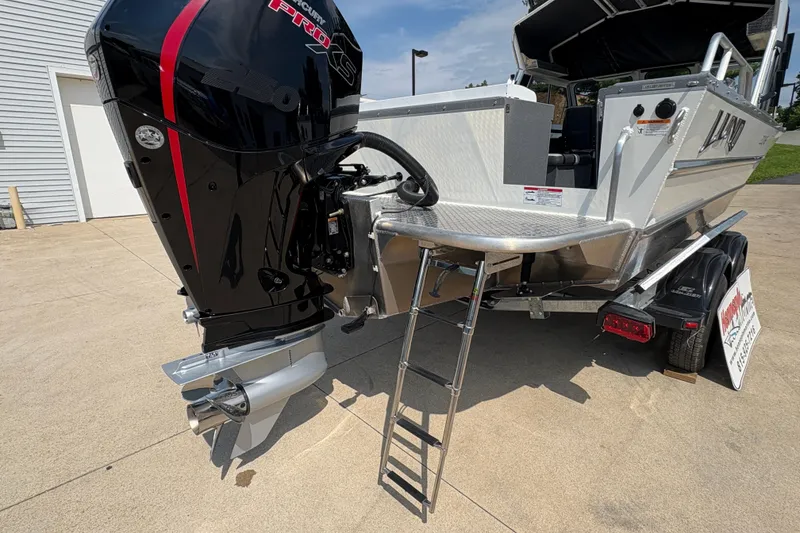 Slide: The Image of 2026 Lund 210 HG boat with powerful outboard motor and ladder on trailer. - 46
