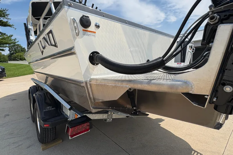 Slide: The Image of 2026 Lund 210 HG boat on trailer, showcasing sleek design and sturdy construction. - 49