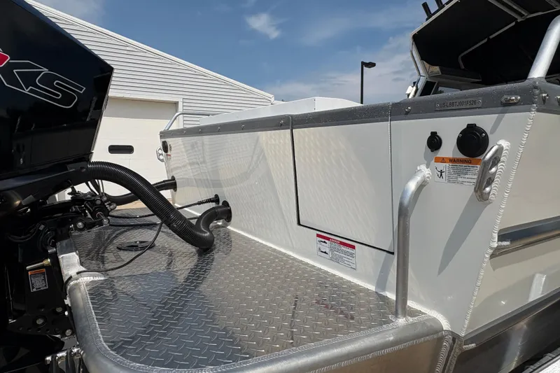 Slide: The Image of 2026 Lund 210 HG boat with metal deck and engine, outdoor setting. - 54