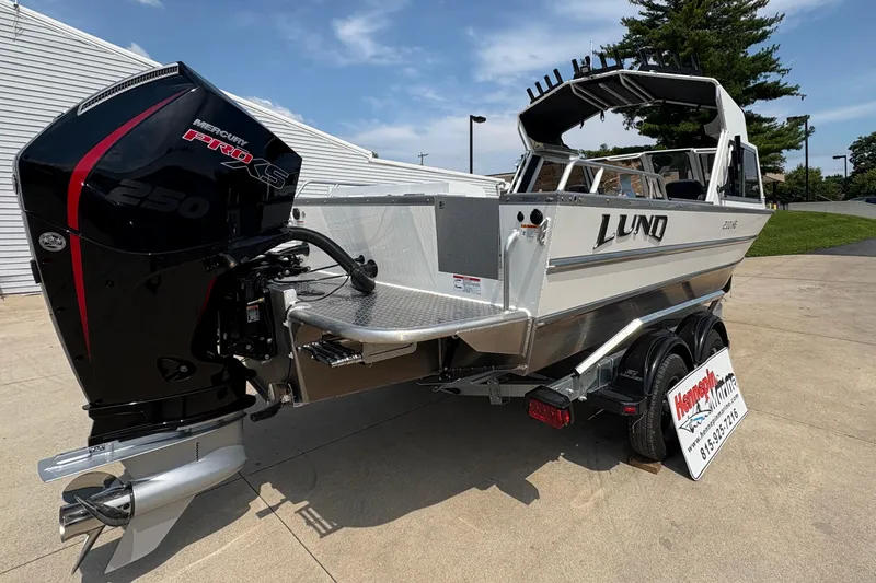 Slide: The Image of 2026 Lund 210 HG boat with Mercury Pro XS 250 engine, parked outdoors. - 7