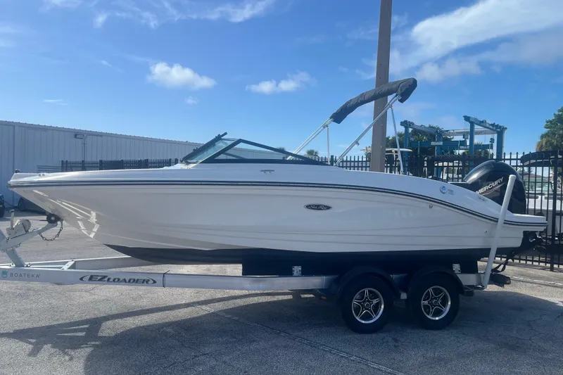 Slide: The Image of 2022 Sea Ray SPX 210 Outboard boat on trailer under clear blue sky. - 2