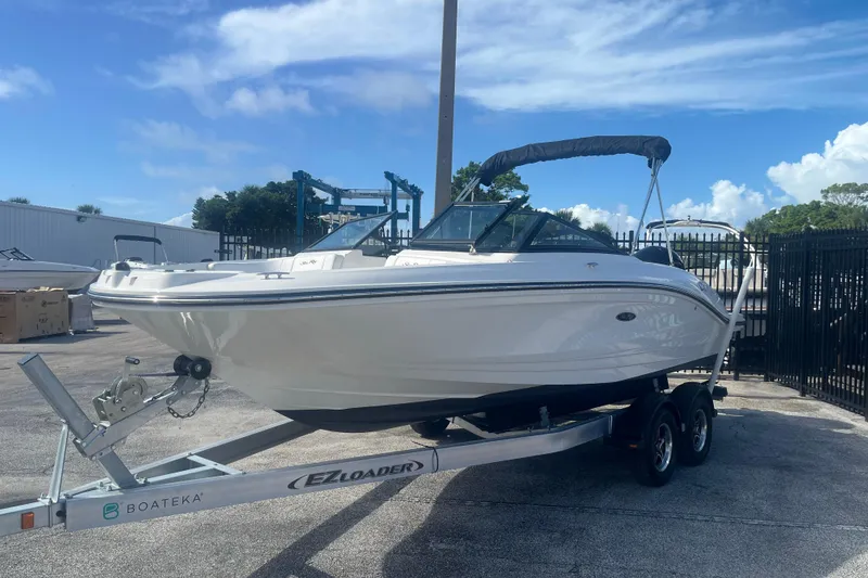 Slide: The Image of 2022 Sea Ray SPX 210 Outboard boat on trailer, parked outdoors under blue sky. - 3