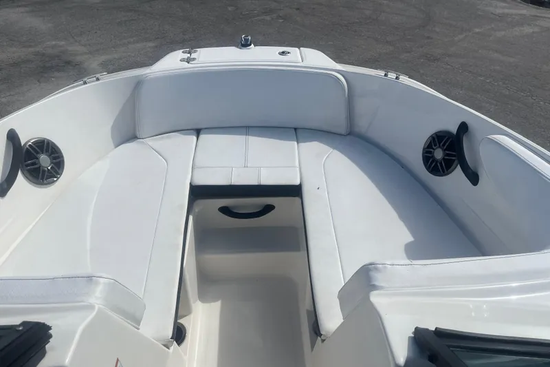 Slide: The Image of 2022 Sea Ray SPX 210 Outboard boat interior with white seating and speakers. - 6